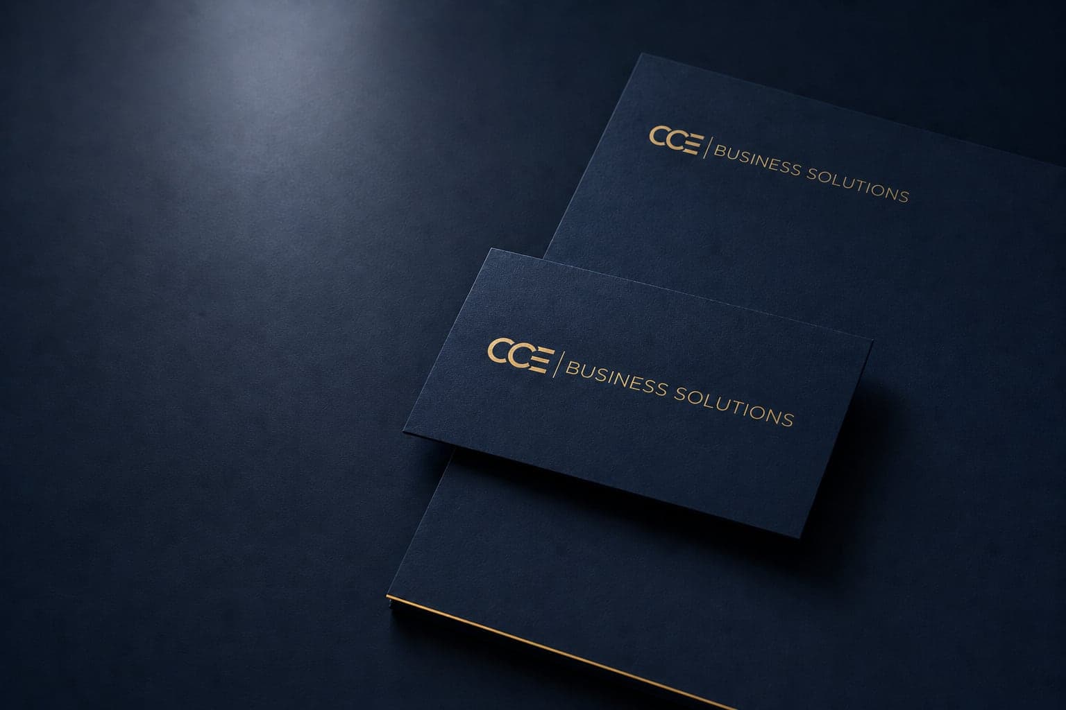 CCE Business Solutions logo in gold on a navy folder and business card